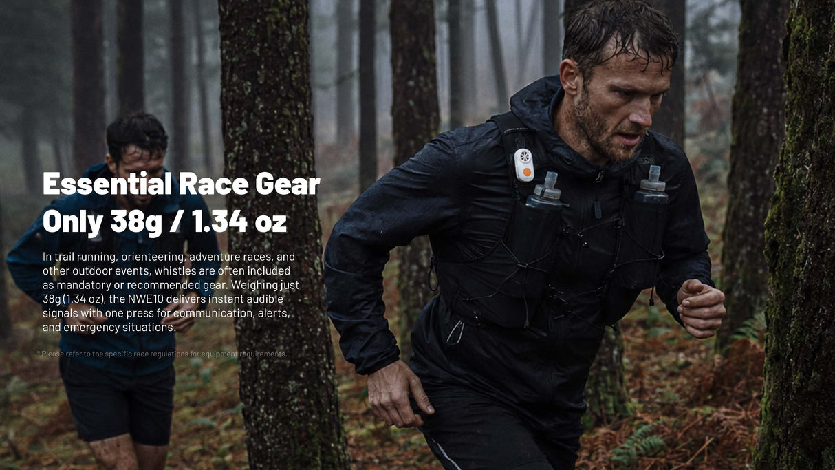 A man running through a misty forest wearing a black waterproof jacket with a hydration pack and a small white electronic whistle on the chest. White text on the left reads 'Essential Race Gear Only 38g / 1.34oz