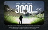 Man standing on a path in the wood illuminating everything with a flashlight and text on the image "Dual Core Output 3000 lumens" and additional promotional text.